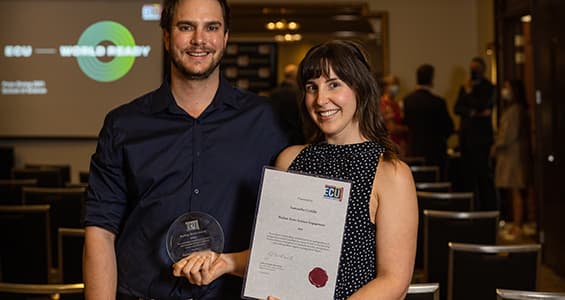 Young woman holds certificate and trophy