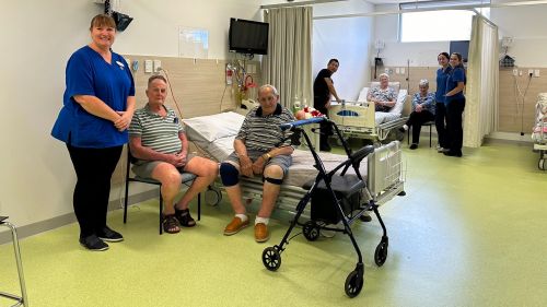 elderly residents in ward with nursing staff