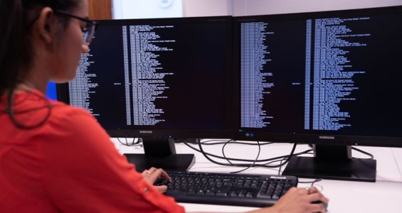 Student sitting a digital monitor displaying data.