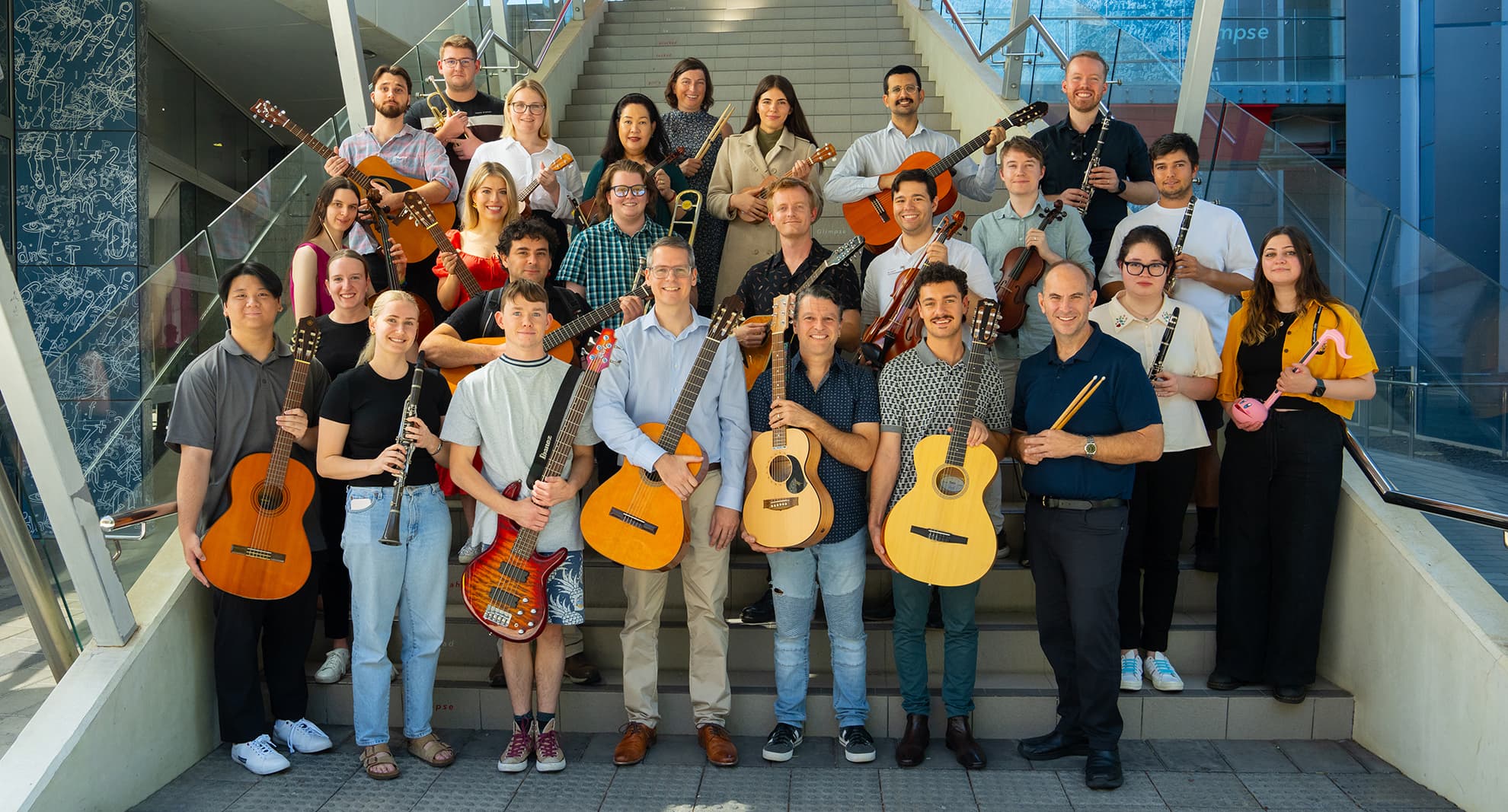 Dr Jason Goopy is pictured with ECU students holding instruments.