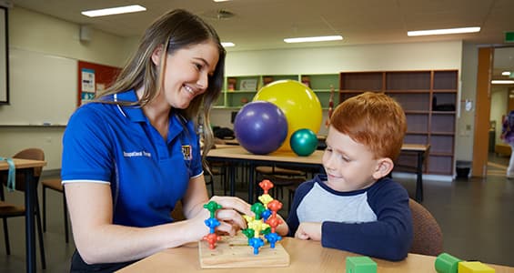 Occupational Therapist sitting at desk with child