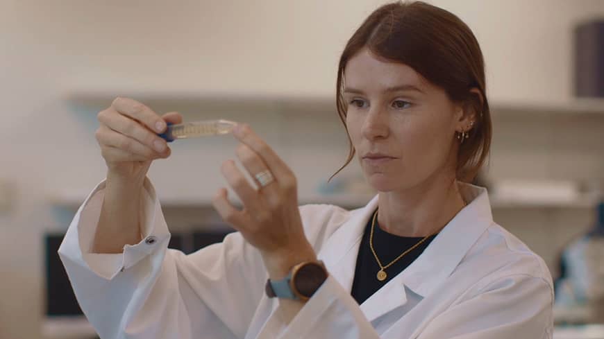 A woman holding a test tube in a lab