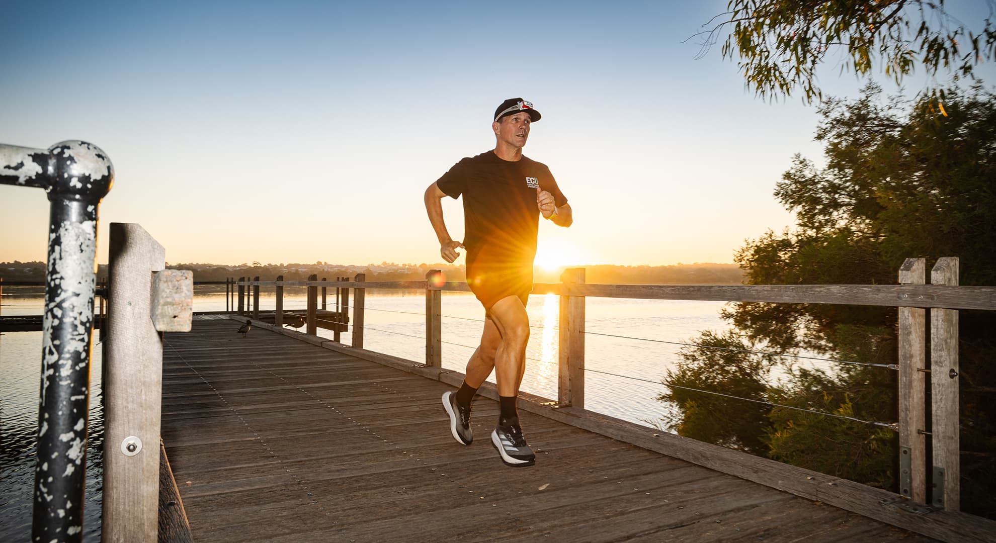A man running with the sunrise behind him