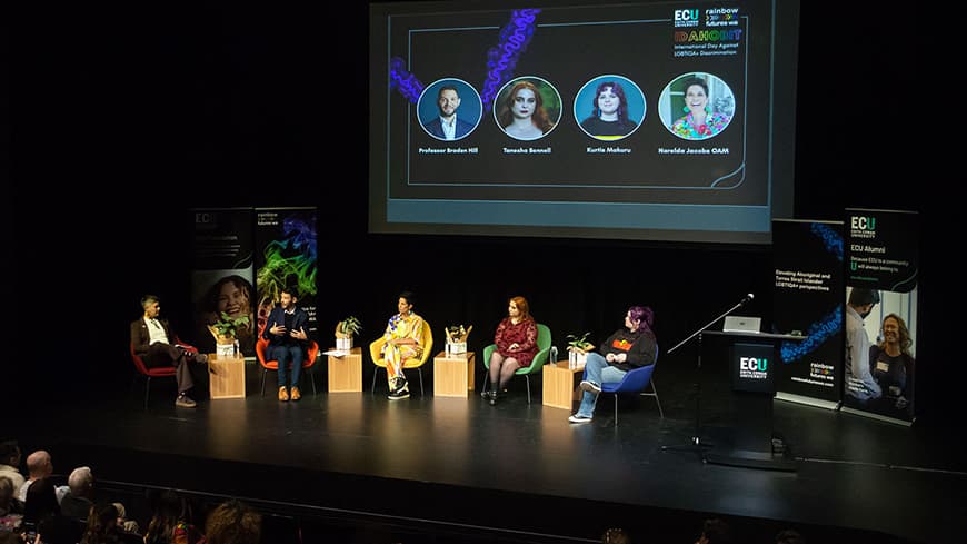 IDAHOBIT Lecture panel members seated on stage.