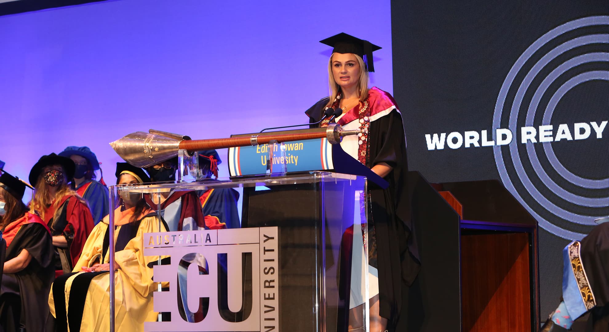 Female university student making a speech at a graduation ceremony.