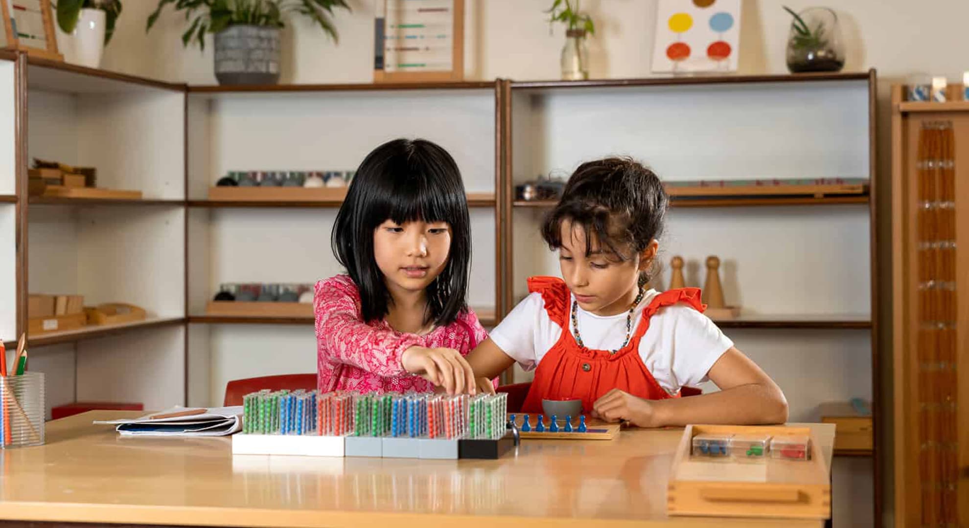 Two girls sitting at a desk doing an activity