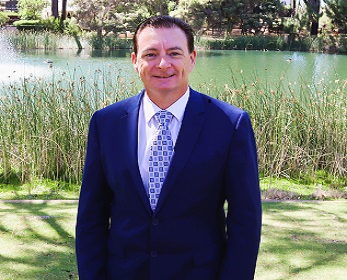 Dr Todd Hutchison standing in front of lake