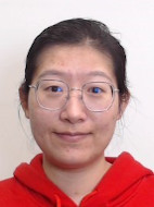 Image of a PhD student wearing glasses and red shirt