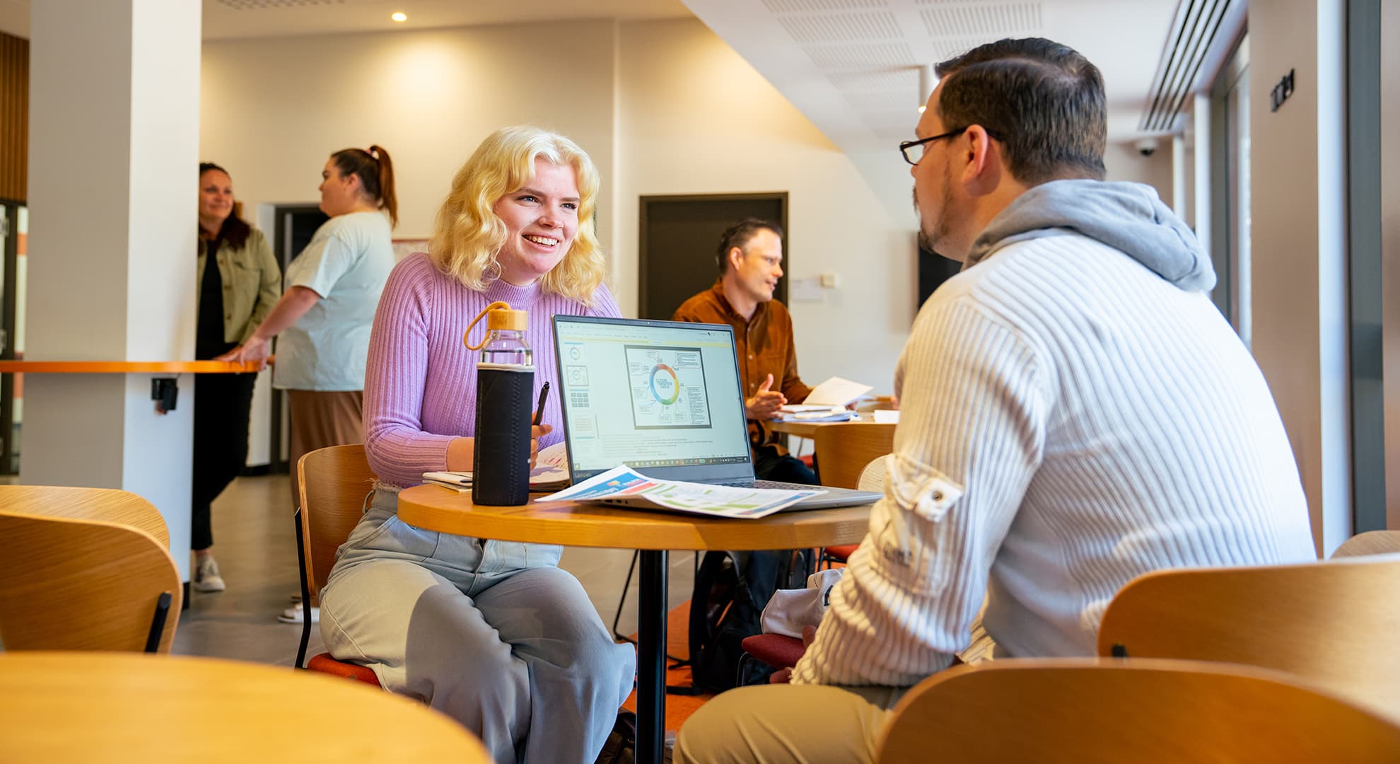 ECU students get are animatedly chatting about university assignments at a study corner indoors.