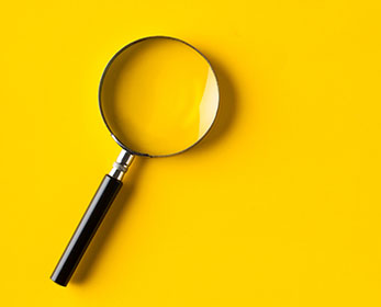 A magnifying glass on a yellow background.