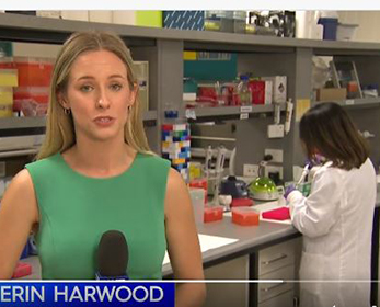 Image of a channel 9 news reporter standing in a centre for precision health research lab