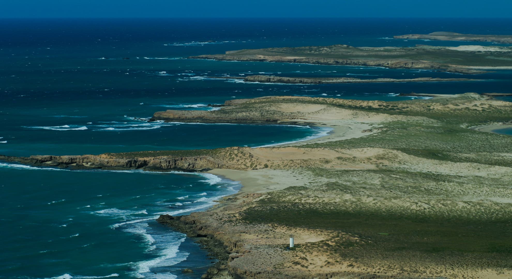 Blue ocean and green coastline.