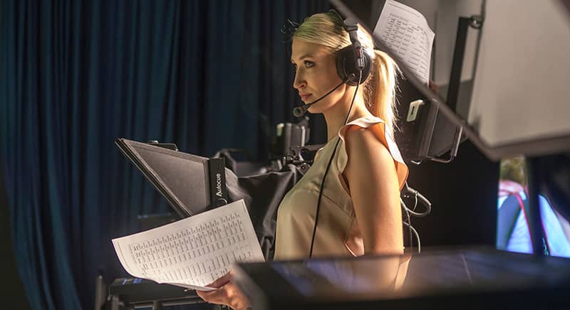 A woman wearing a headset on the set of a production