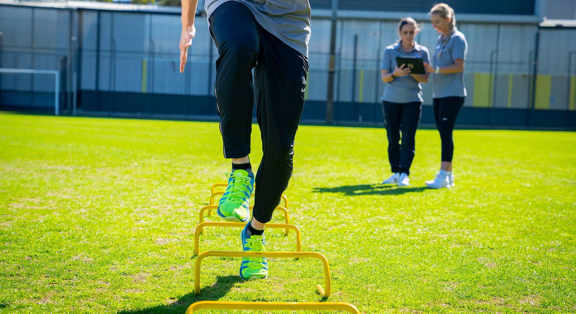 Man running drills with two women in the background