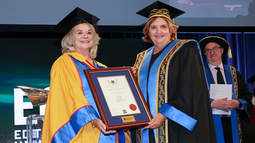 A woman, Jacqueline McGowan-Jones, receiving an award from a woman, ECU Chancellor Gaye McMath