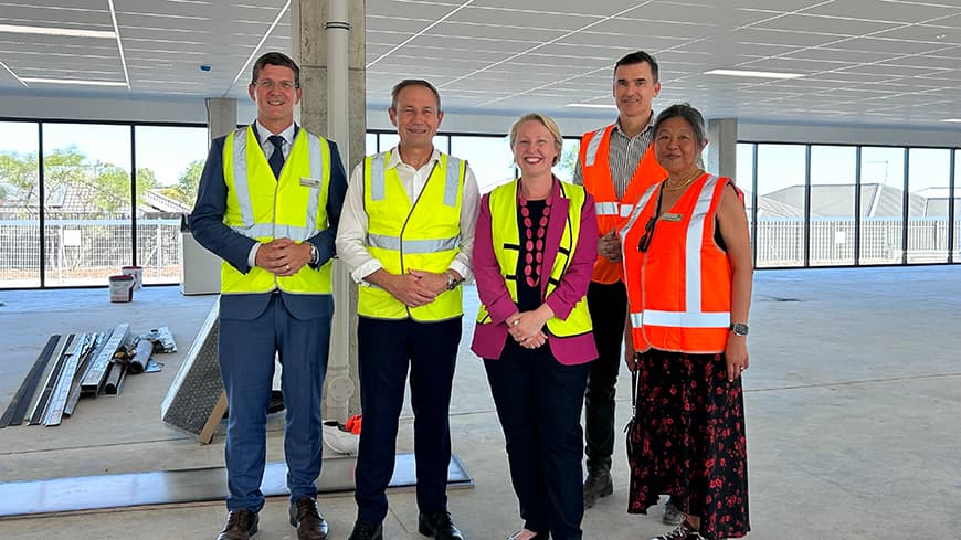 A group of people standing inside a newly constructed building.