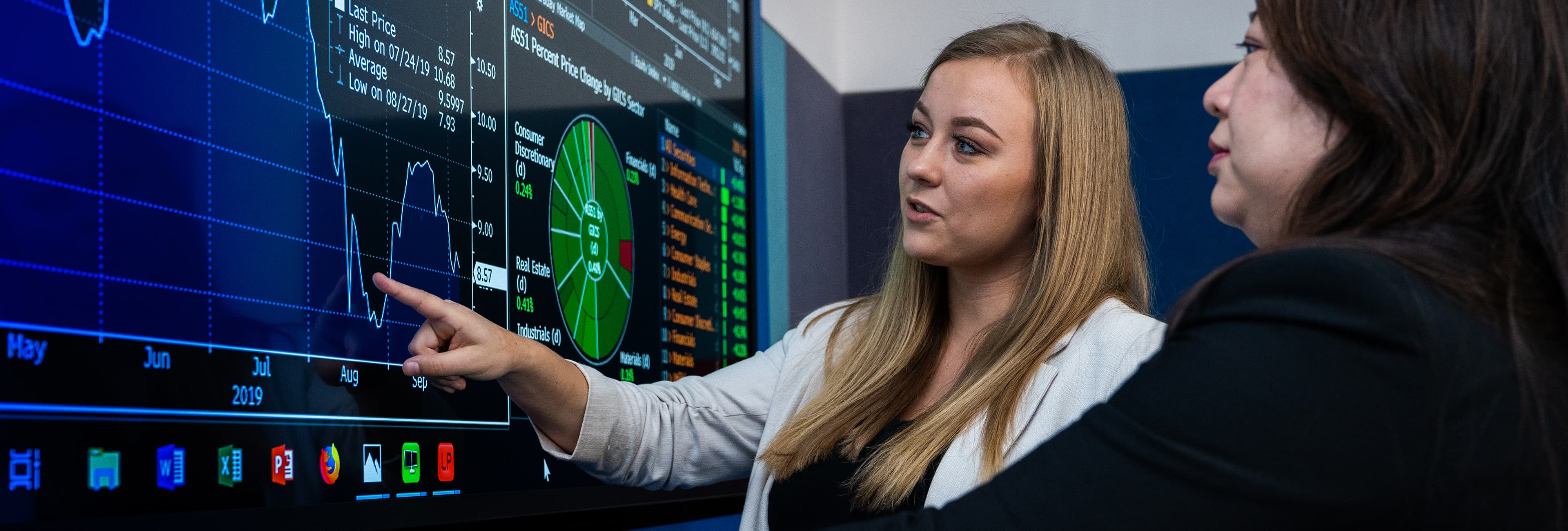 ECU Business student and lecturer viewing a media screen