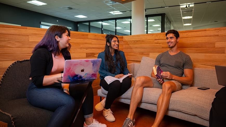 Postgraduate students sitting working together at ECU Library