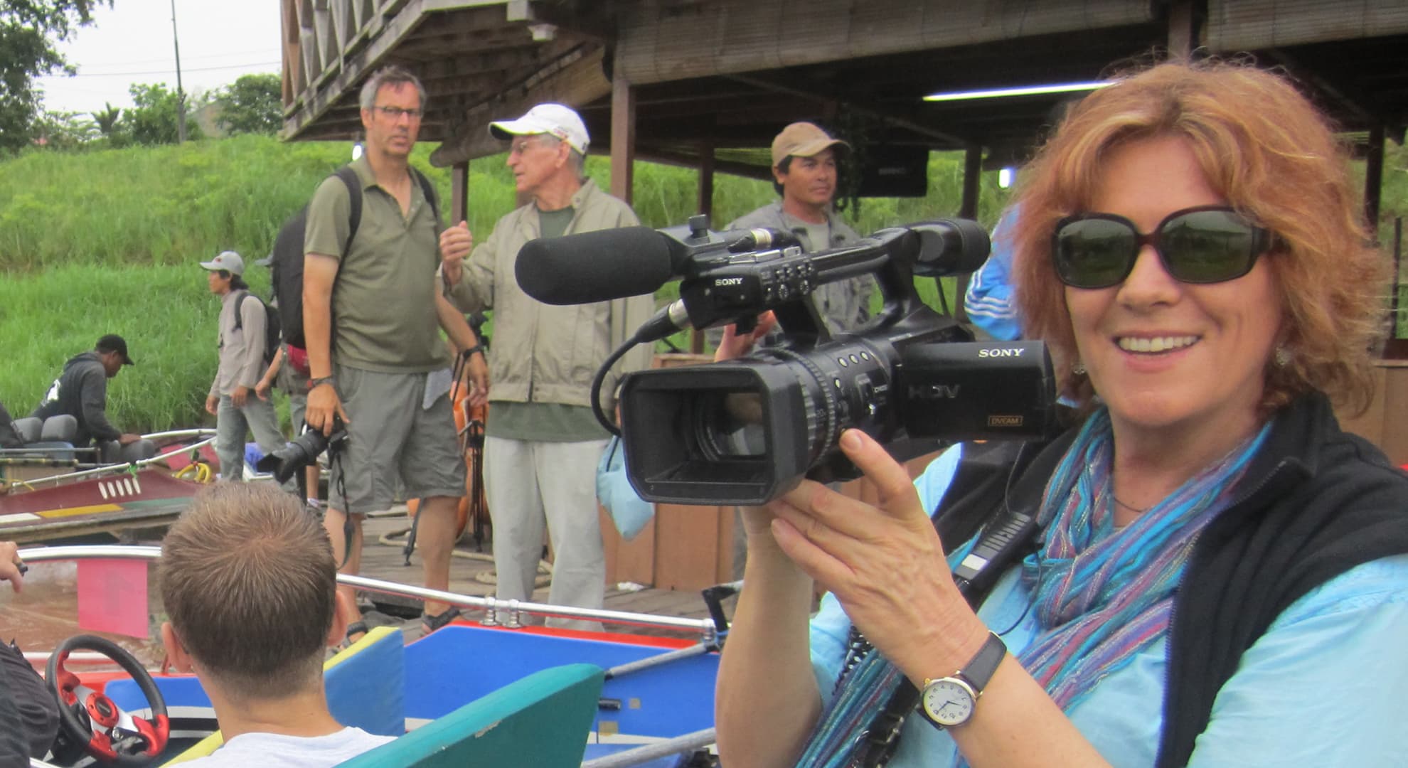 Cathy Henkel holding a camera filming a documentary in Borneo