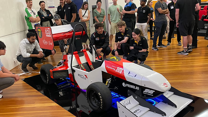 The team standing around the car smiling