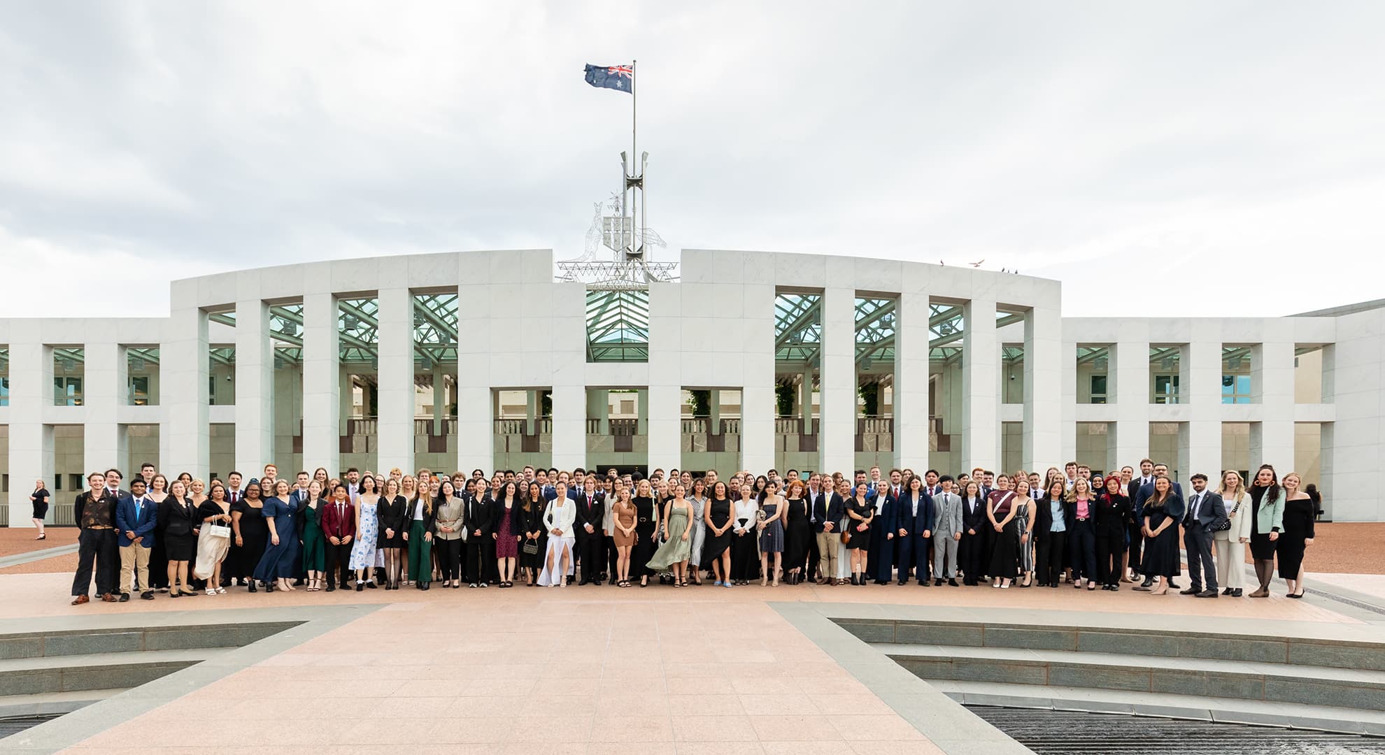 150 Australian undergraduates who were awarded the NCP Scholarship stand in front of Parliament House.