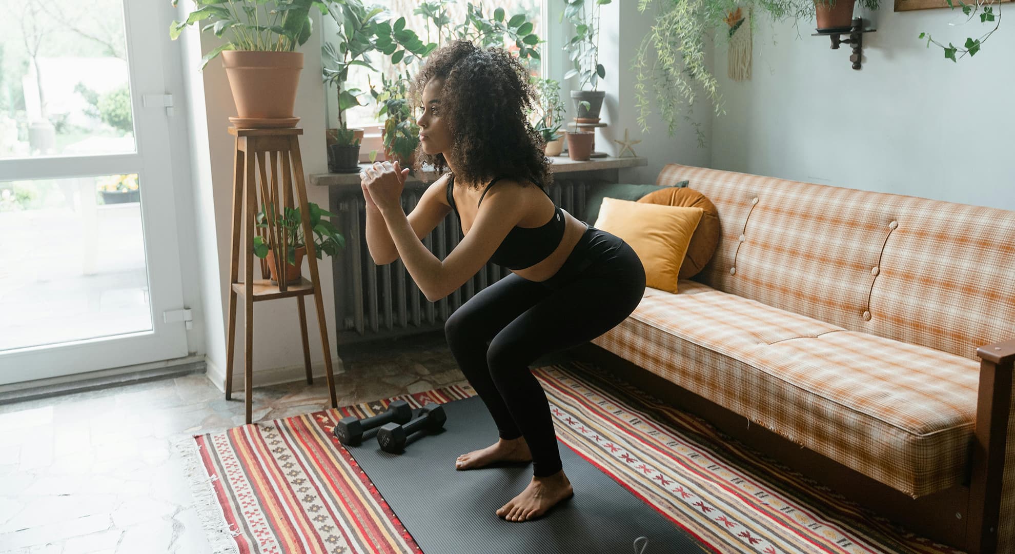 Woman doing squat in a living room.