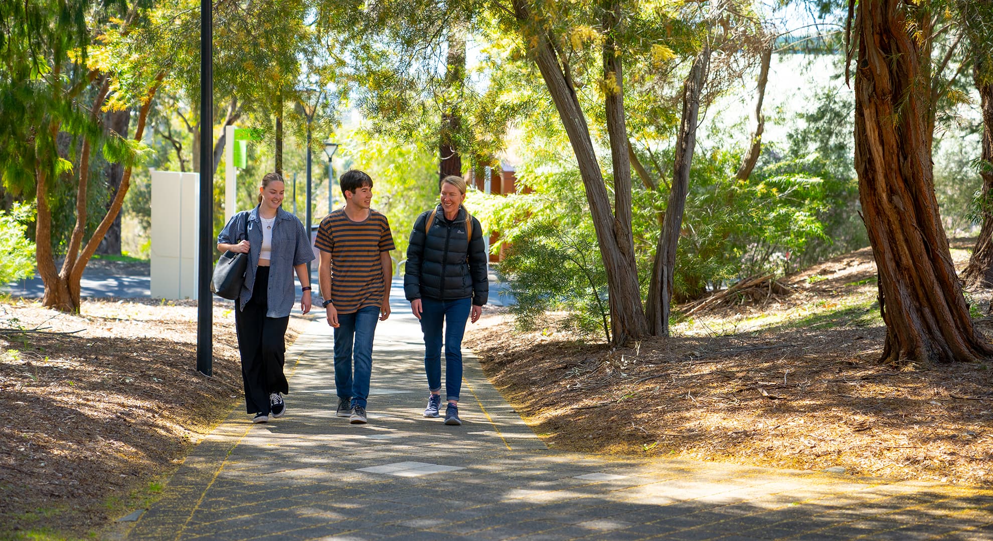 Three students walking and smiling
