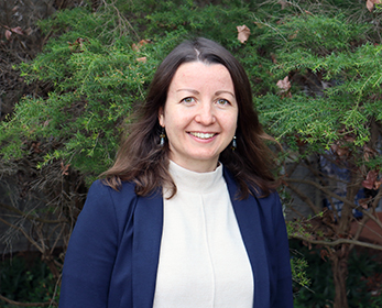 A portrait image of Dr Tetiana Bogachenko smiling in front of a tree