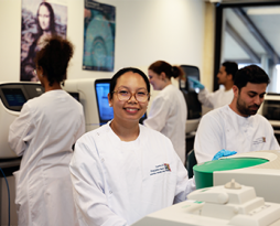 Photo of a team in the lab with white lab coats on