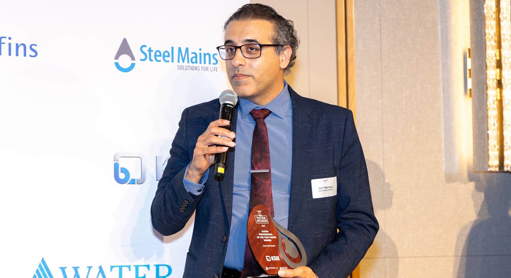 Man speaking while holding an award