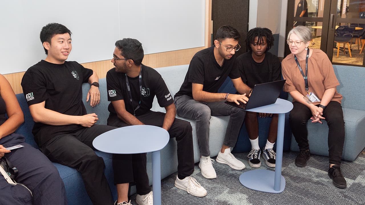 A mentor and a group of students talking