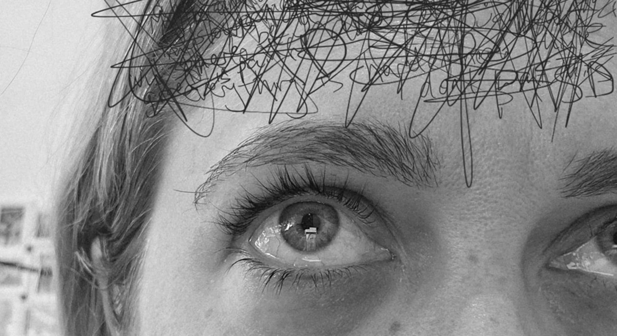 A close up of a woman's face with scribbles added to her forehead.