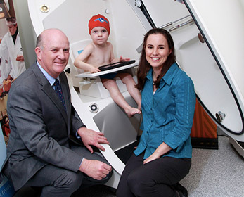 Milky Way Study lead researcher Dr Therese O’Sullivan and Minister for Health, the Hon John Day, help assess Xavier’s body composition in the BOD POD. Courtesy of the Community Newspaper Group