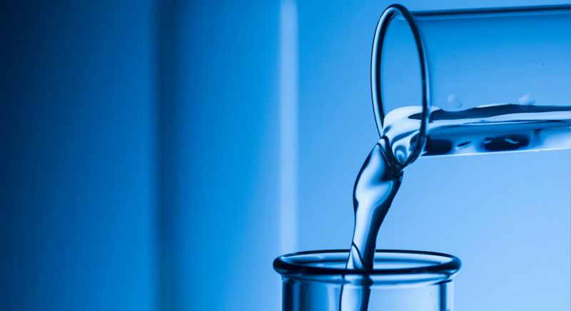 Close-up of liquid being poured in flask