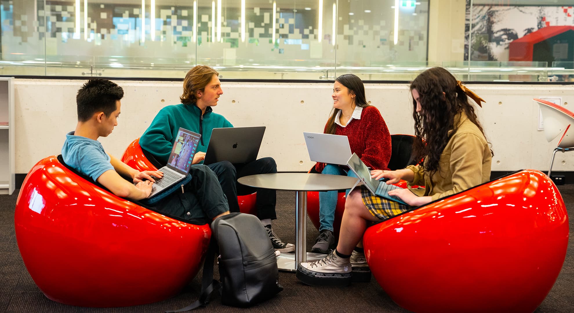 Female and male students sitting together in a meeting room.