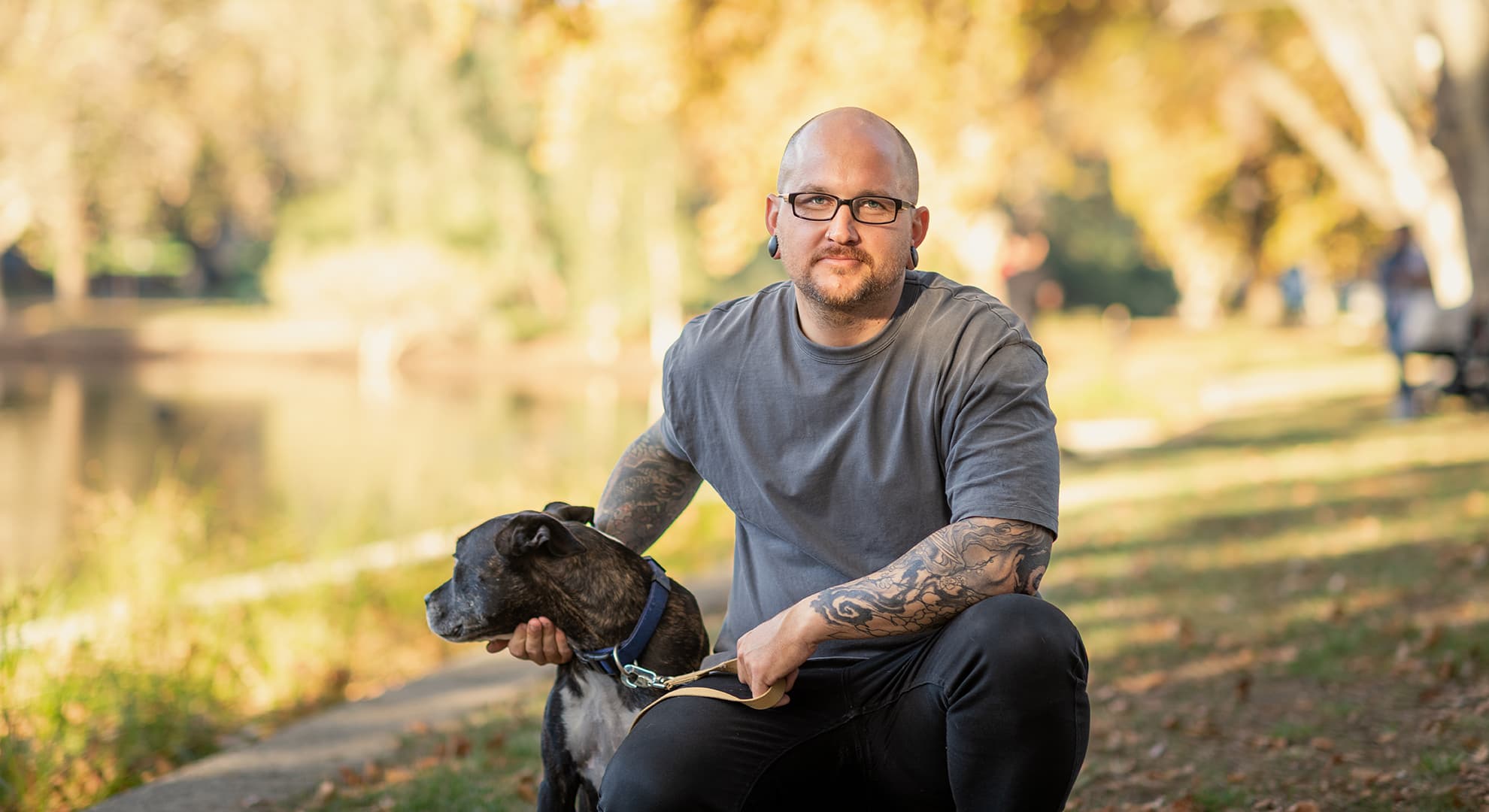 Man sitting in a park with his dog.