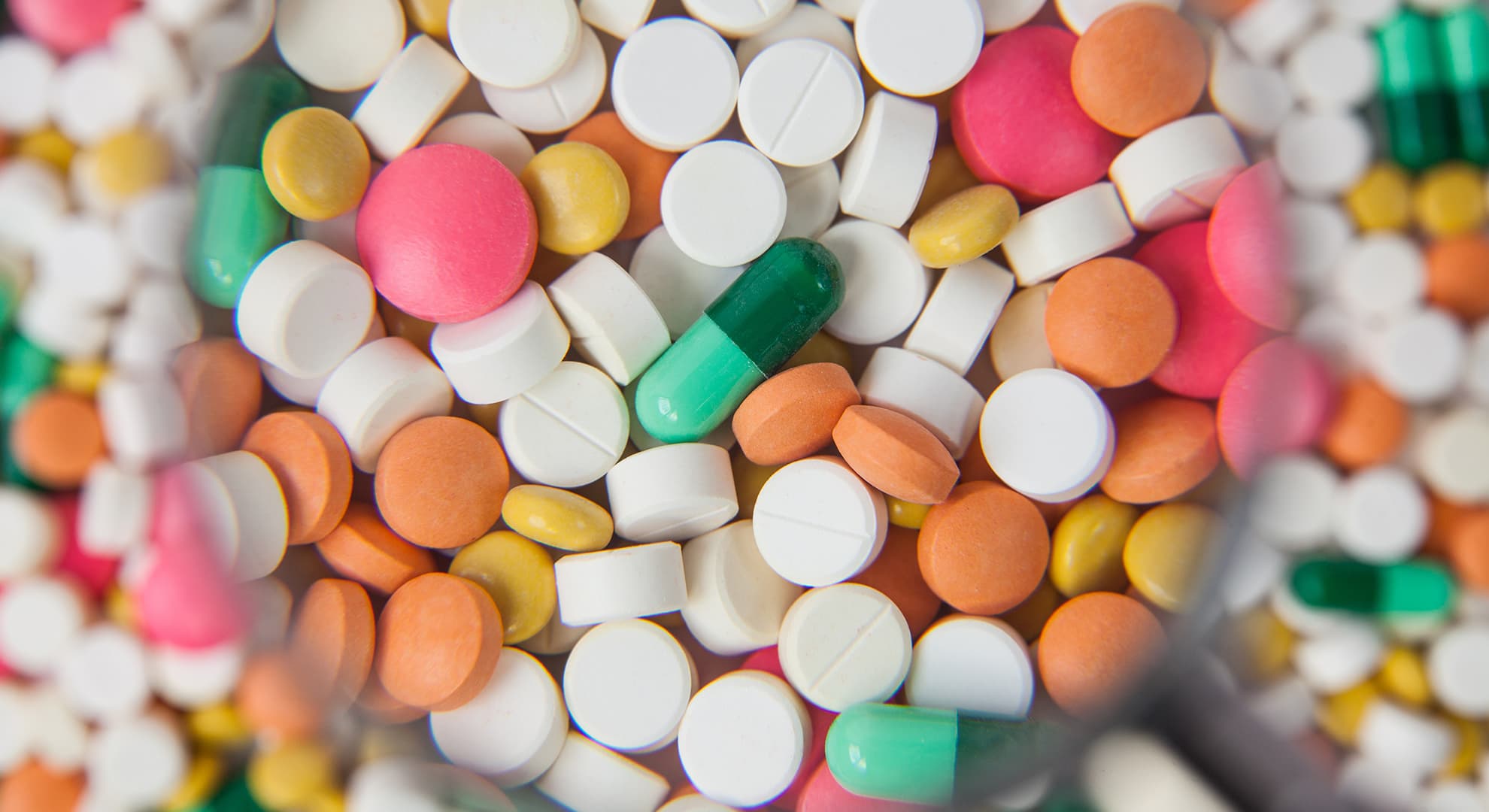 Close up of a variety of pills of several different colours.