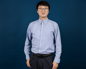 Dr Xuan Sean Sun in front of a navy blue background