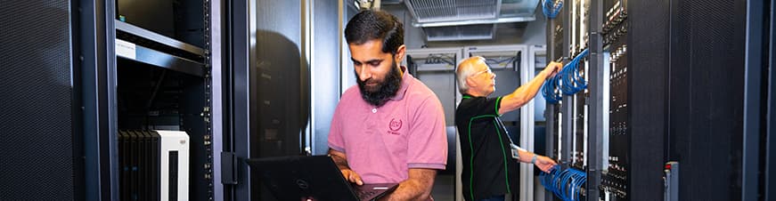 Man standing in hallway looking at computer screen