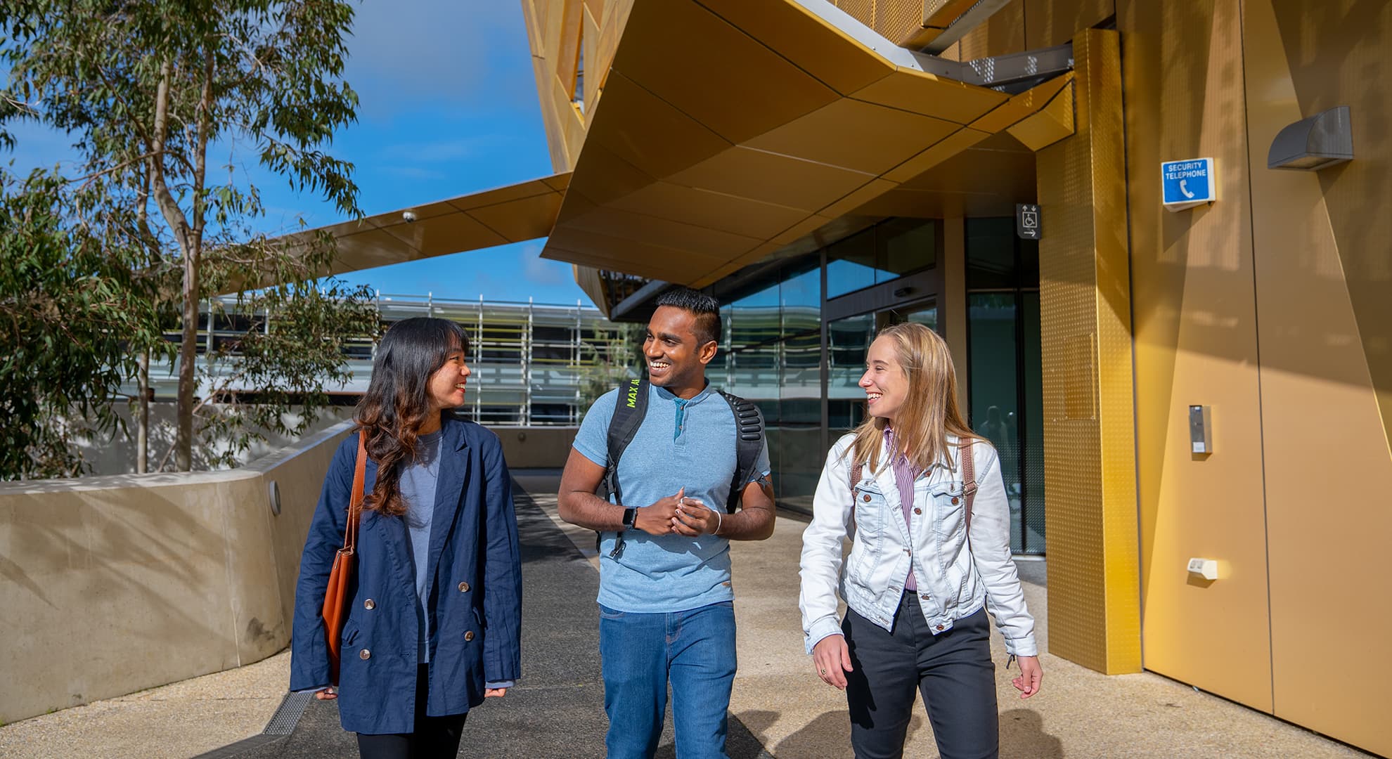 Students walking through the ECU Joondalup Campus entrance smiling