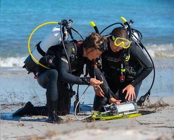 Divers checking a PAM fluorometer after diving.