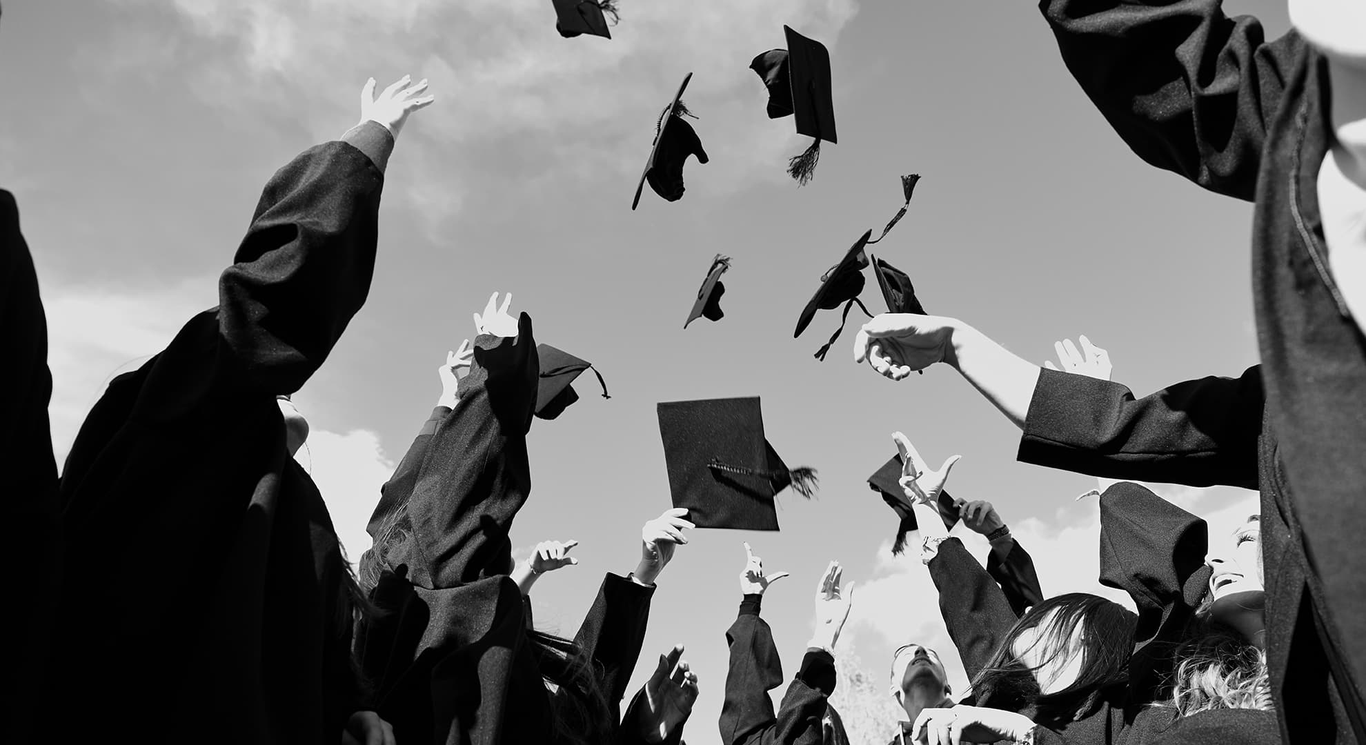 Graduating students throwing their mortar boards in the air