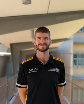 Photo of a male postdoctoral researcher wearing a polo shirt