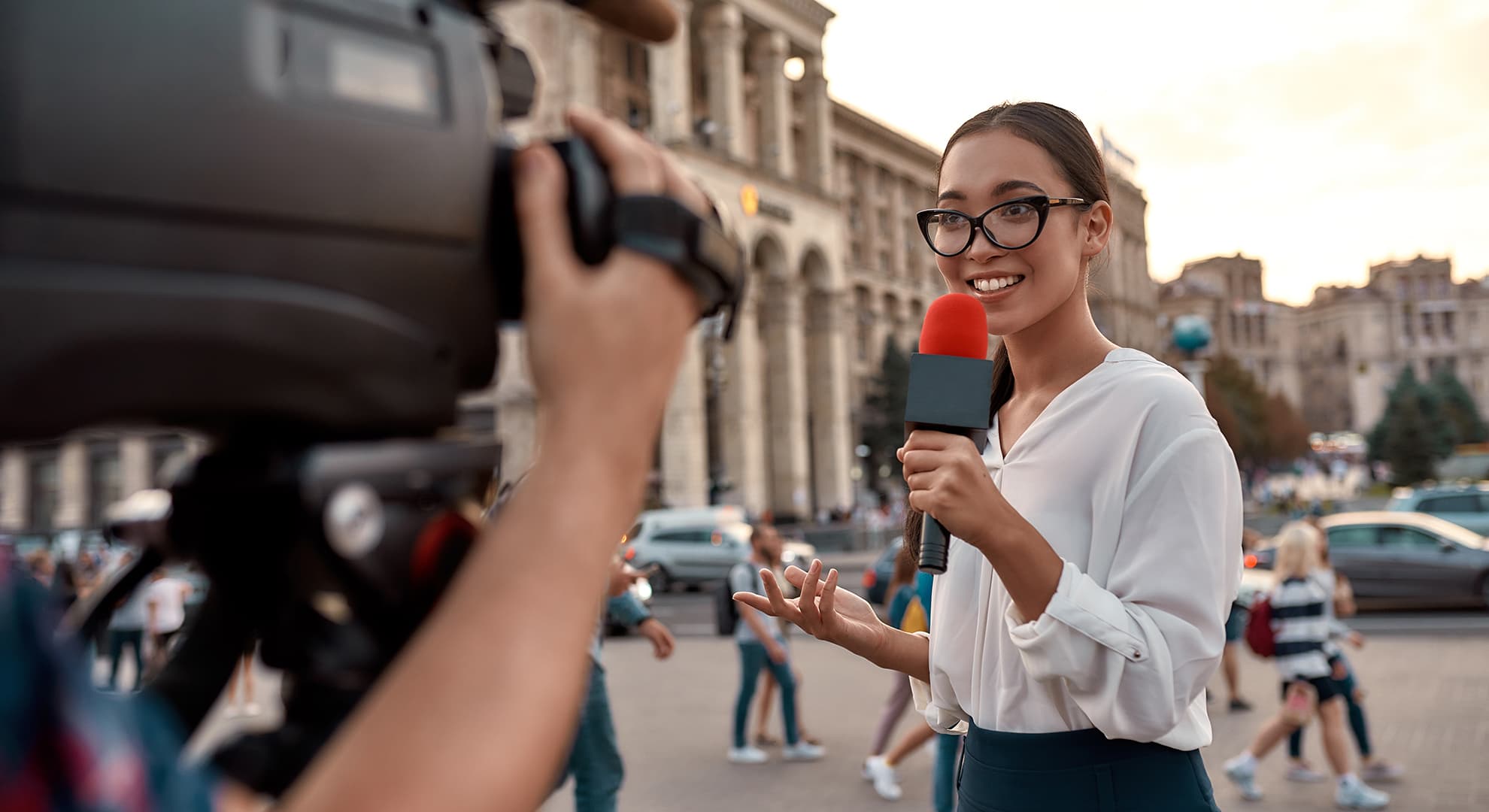 journalist with microphone in front of camera