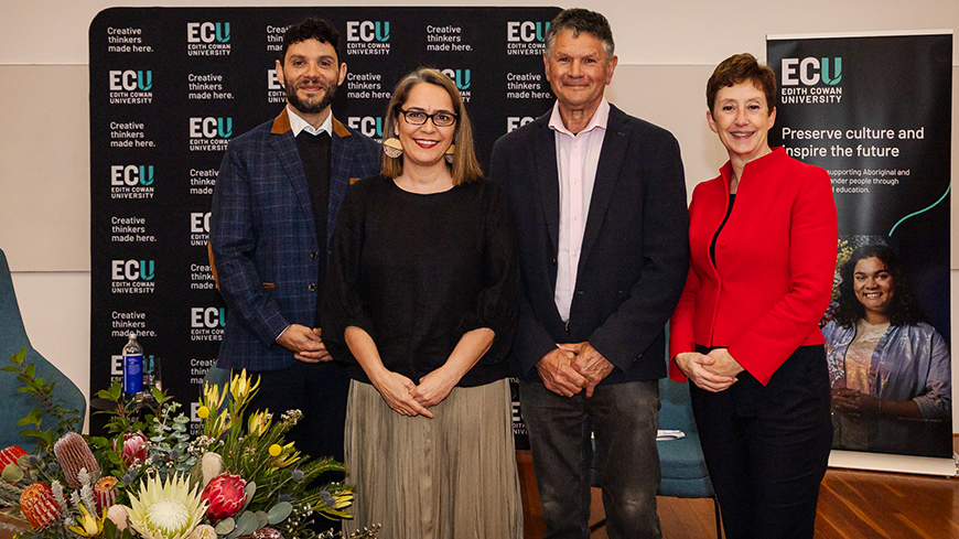 Four people posing for a group photo
