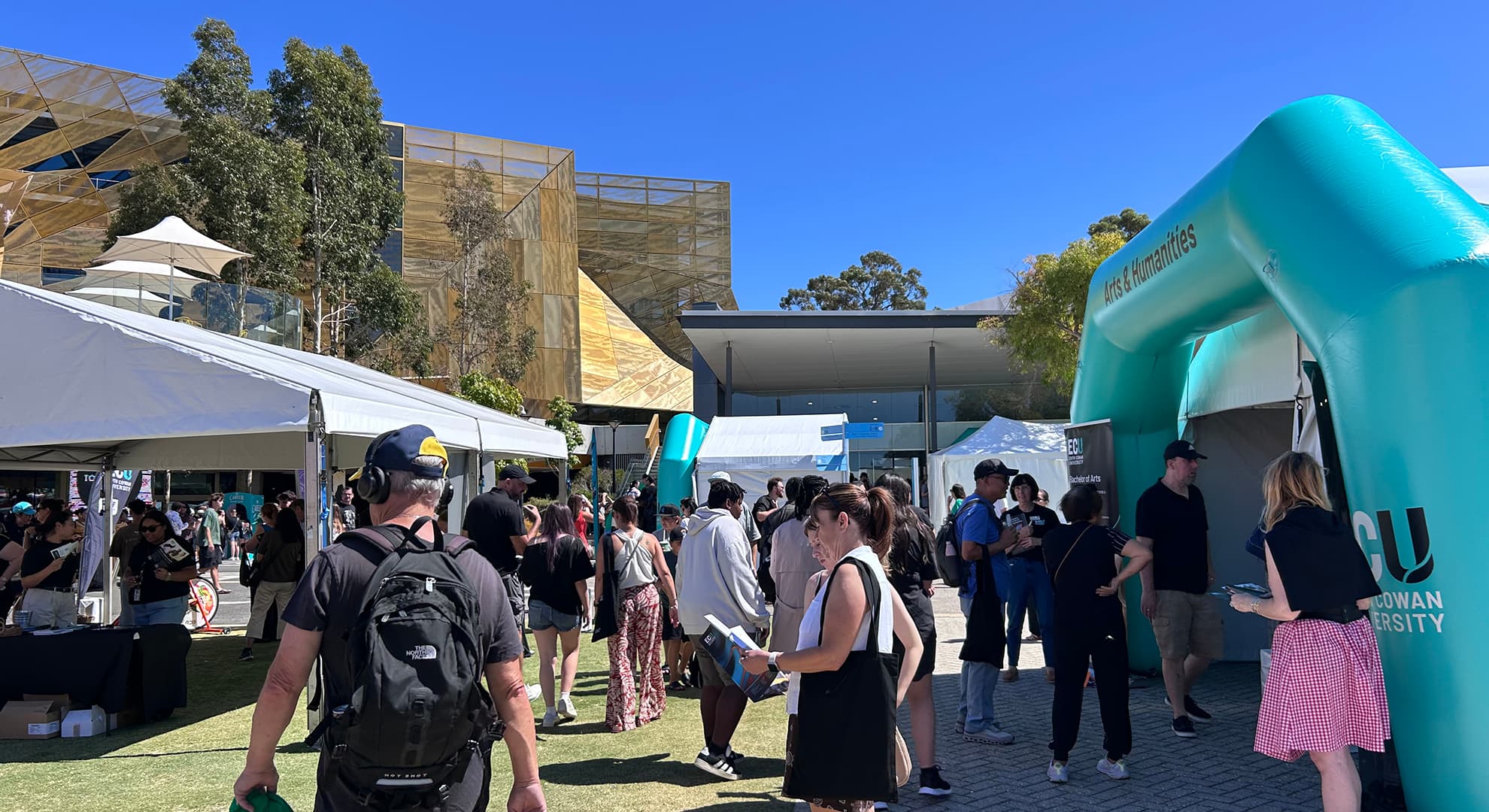 People gathered outdoors on campus at a university open day..