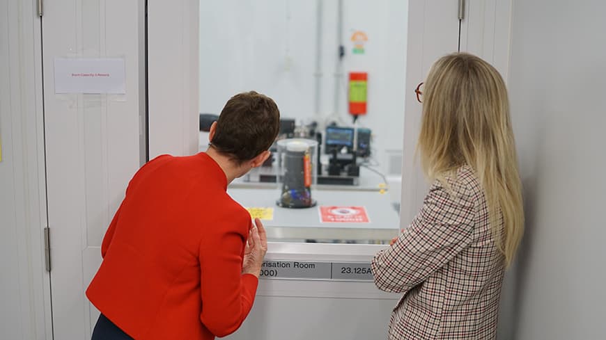 ECU Vice-Chancellor Professor Clare Pollock and Parliamentary Secretary to the Minister for Defence Industries, Caitlin Collins, look into the cleanroom through a window