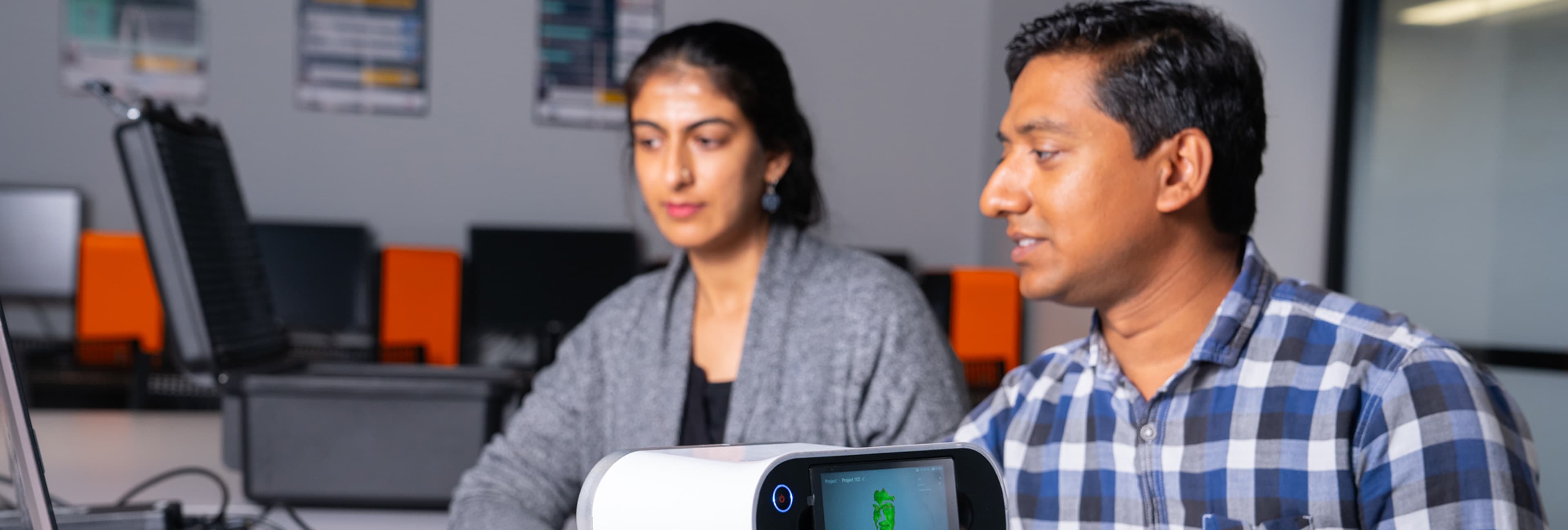 Man and woman studying data on computer screen