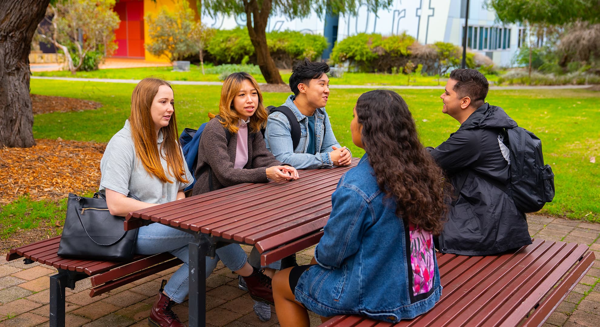 six ECU student sitting at a table outdoors at the Mount Lawley Campus talking