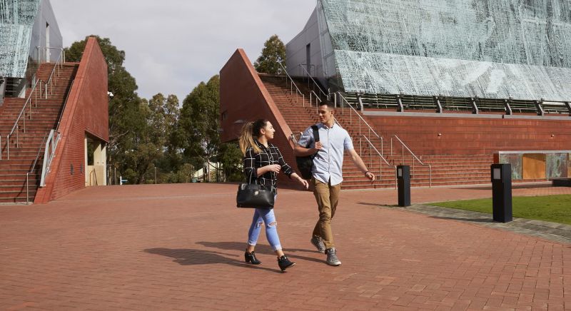 Two students walking near Building 1 at Joondalup campus
